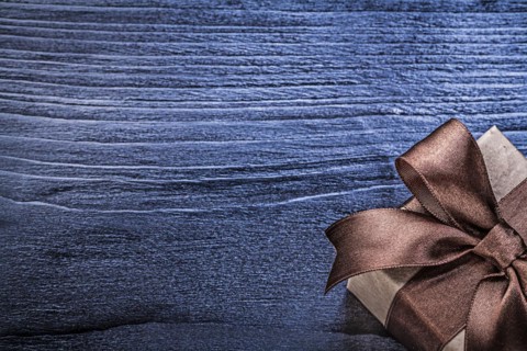 Gift box with present on wooden board copy space