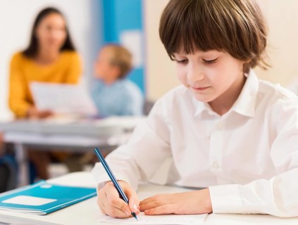 Kid writing his notebook during class