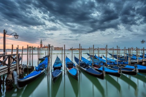 Gondolas on St Mark's Square in Venice, Italy, during a dramatic sunrise, Europe