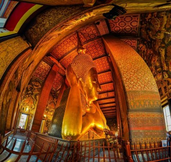 Photo of large lying golden Buddha statue in temple Wat Pho in capital city in Bangkok, Thailand,