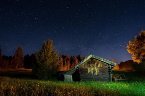 Wooden barn under a nigth sky full of stars