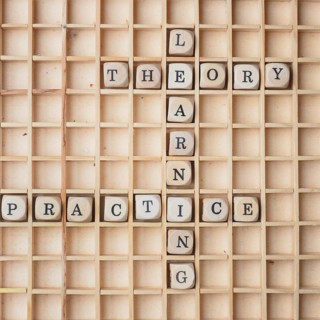 Learning concept with wooden dices and the words theory and practice