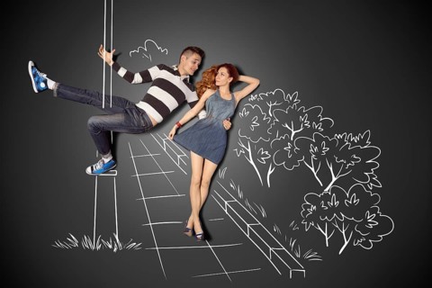 Happy Valentine's Day love story concept of a romantic couple against chalk drawings background.