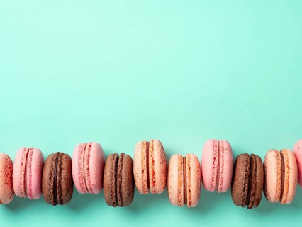 Macarons with copy space. Row of perfect french macarons or macaroons on blue turquoise background.