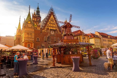 Wroclaw, Poland, June 21, 2019: Old Town Hall and decorative windmill at Market Square, stalls with