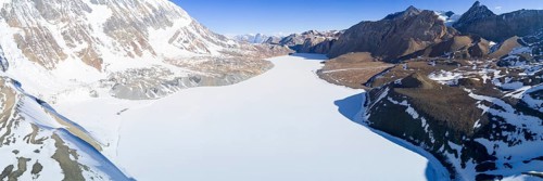 Aerial view of high altitude Tilicho Lake frozen and covered with snow in the Himalaya mountains of