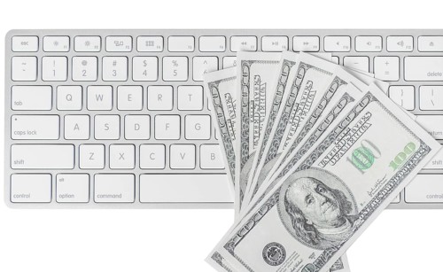 US hundred dollar bills with white computer keyboard isolated on white background