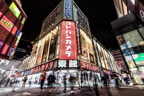 TOKYO, JAPAN - MAY 18 2019: Neon signs illuminate Tokyo's busy Shinjuku neighborhood at night
