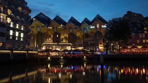 Night view of waterside with outdoor cafes near the cubes houses in Rotterdam, Netherlands