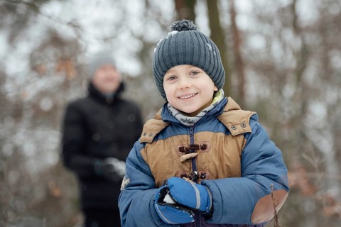 Six year old boy smiling during makeing snowball