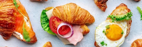 Croissant sandwich variety panorama. Different stuffed croissants, overhead flat lay shot. Rolls
