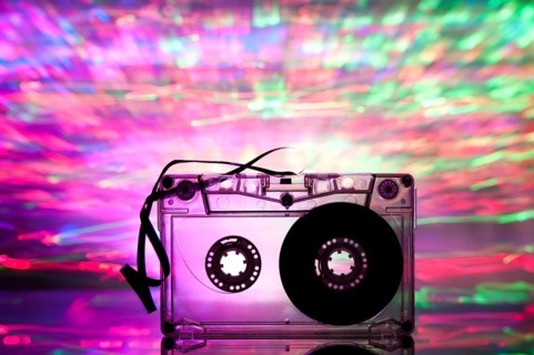 Cassette tape and multicolored pink blue lights on background