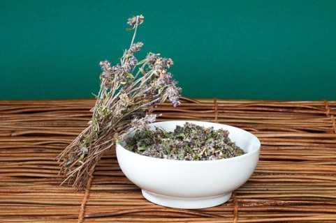 Dried thyme in a bowl on a wooden base