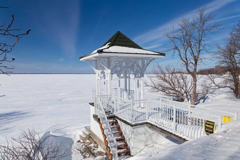 Winter, small private pavilion next to the snow and ice covered Saint Lawrence River, Lery,