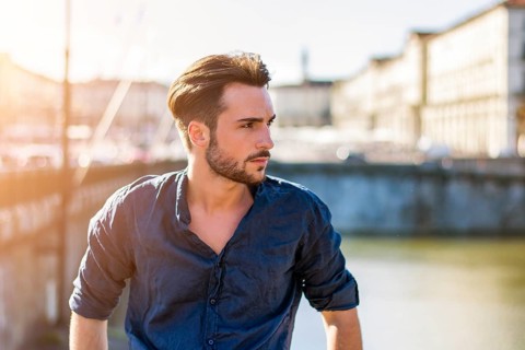 One handsome young man in urban setting in European city, Turin in Italy by the river Po