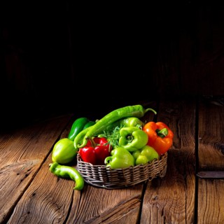 Various harvested peppers and hot peppers in basket