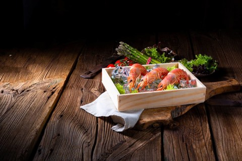 Cooked argentine red prawns with salad on the ice