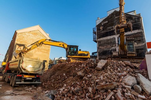 Excavators on a building site demolishing a house, creating space for new flats and living space