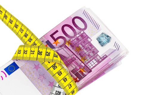 Banknotes and tape measure, symbolic photo for austerity measures, budget consolidation and