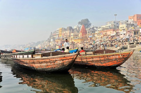 Varanasi, Uttar Pradesh, India, Asia, Two boats floating side by side on a river with urban scenery