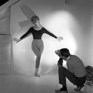 1950s photographer. A woman is posing for a photographer wearing a typical 1950s black jumper and