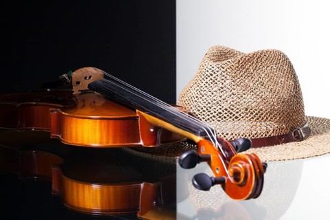 Old violin and straw hat isolated on black and white background and glass desk