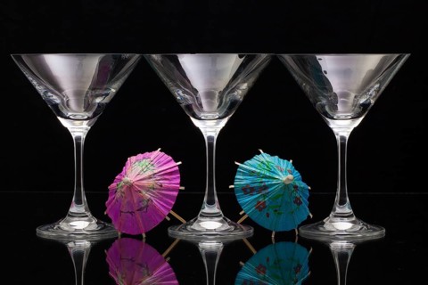 Three empty glasses of champagne with decoration (paper umbrellas)