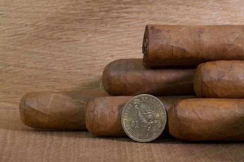 Luxury Cuban cigars with US dollar on the wooden table