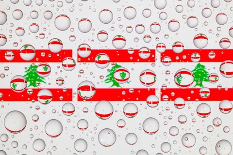 Flags of Lebanon behind a glass covered with raindrops. 3D illustration