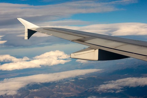 Airplane during flight with the sky and clouds on the background