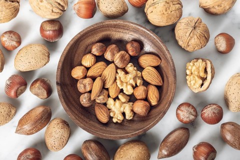 Nuts Mixed in a wooden plate.Assortment, Walnuts, Pecan, Almonds, Hazelnuts. Healthy appetizer