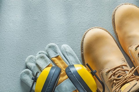 Safety lace boots protective gloves earmuffs on concrete background