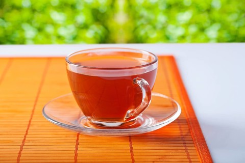 Transparent cup with tea on table