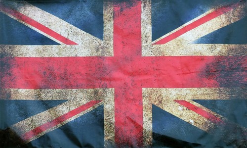 A full frame image of an old stained dirty union jack british flag with dark crumpled edges
