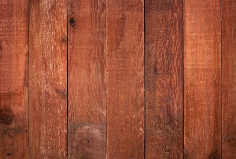 Red weathered barn wood background with knots and nail holes