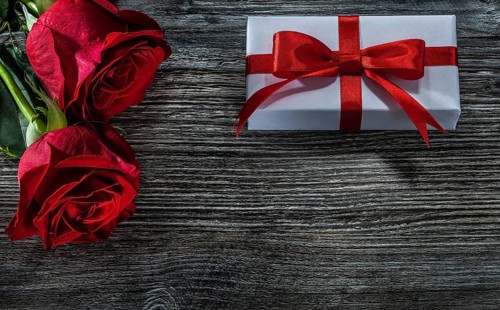 White gift boxes red roses on wooden board