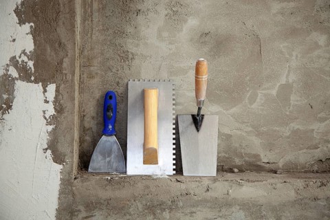 Construction stainless steel trowel tools and spatula on cement mortar wall