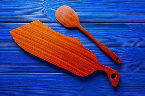 Chef tool spatula and table board on a blue wooden background
