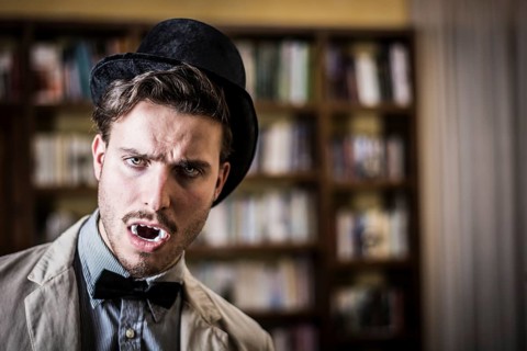 Close up Young Handsome White Vampire with Black Top Hat Inside the Mini Library