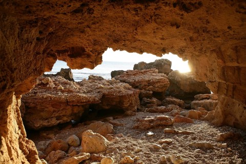 Cave entrance view from interior with light coming in, beach