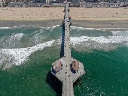 Aerial view of Huntington Pier, beach and coastline during sunny summer day, Southeast of Los