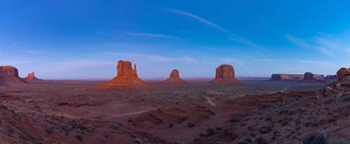 A panorama picture of the Monument Valley landscape in the early evening or night, with the West