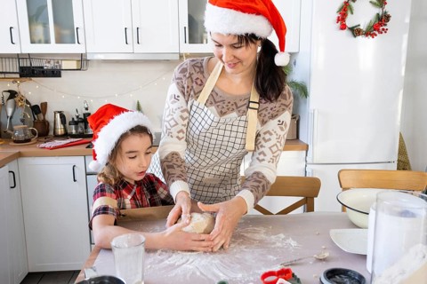 Mom and daughter in the white kitchen are preparing cookies for Christmas and new year. Family day,
