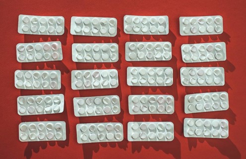 Packs of pills on red background