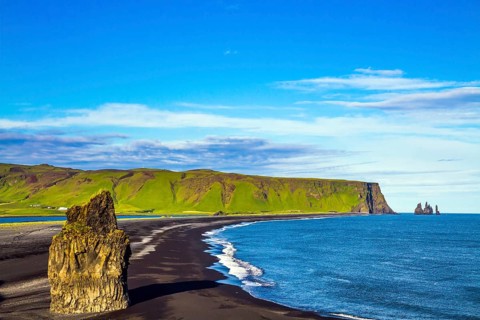 Cape Dyrholaey. The southern edge of Iceland. Beach with black volcanic ash Reinisfjara. Giant