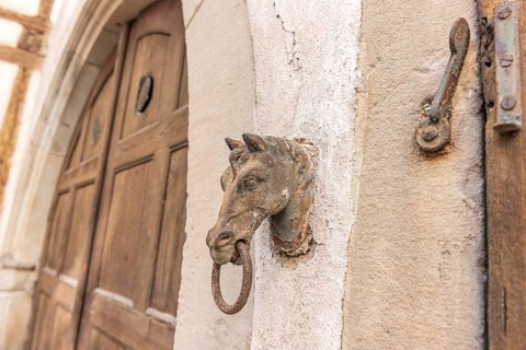 Old rusty horse's head with a ring for tying horses in a backyard. Colmar, Haut-Rhin, Collectivite