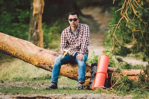 Eating banana Outdoors Hiking Trail. theme hiking and nature travel. Tourist take a rest and eating