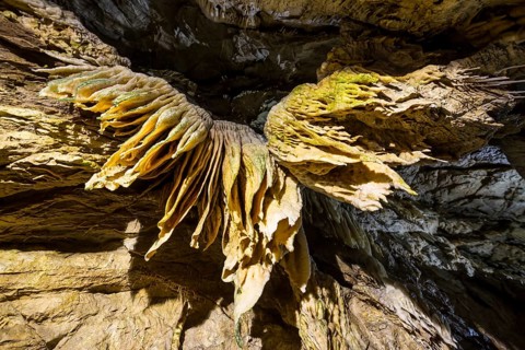 Inside of a beautiful colourful cave. Flowstones, stalactites and stalagmites lighted in different
