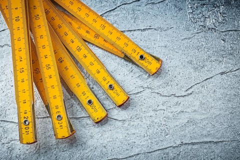 Wooden meter on metallic background top view construction concept