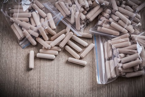 Wooden dowels on wood board close up view construction concept